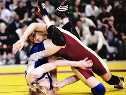 Two people geared up and in active wrestling match