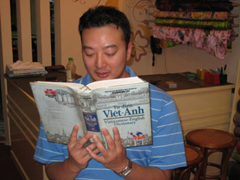 Picture of a reporter Thien Huynh reading a learning vietnamese book
