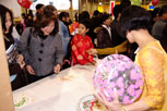 A mature looking woman looking at a vietnamese craft