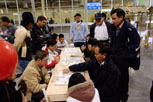 another image of people playing chinese chess, this time with additional observers standing around them