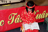 A young girl reading a vietnamese writing book