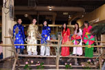 6 young people wearing traditional vietnamese costumes balancing on a wooden beam